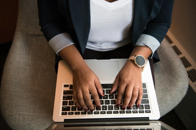 A person typing on their laptop