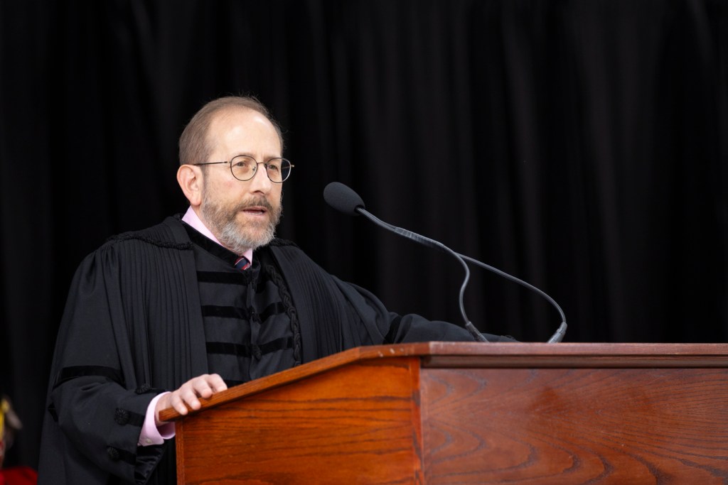 Aland Garber standing at a podium speaking.