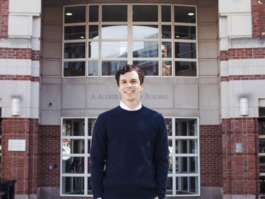 Jeremy Ney in a sweater outside a building