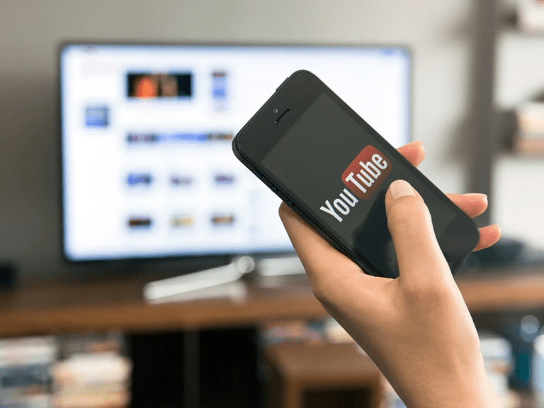 A hand holds a phone that is opened to YouTube