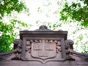 The Harvard shield at the top of a cement gate