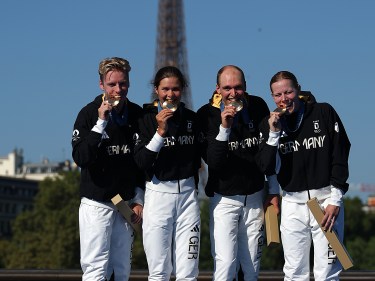 Team Germany poses at the podium during the Triathlon medal ceremony at the Paris Olympics.