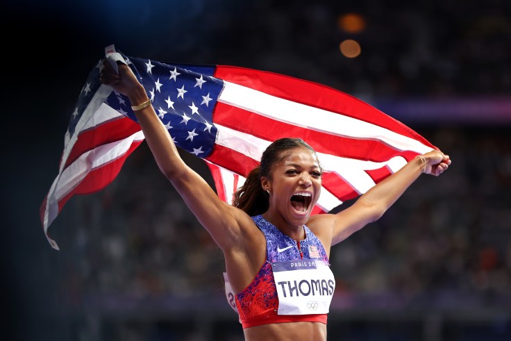 Gabby Thomas holds an American flag at the Paris Olympics