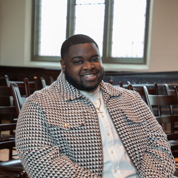 Ke'Von Singleton sits in a chair inside a building at Harvard Divinity School.