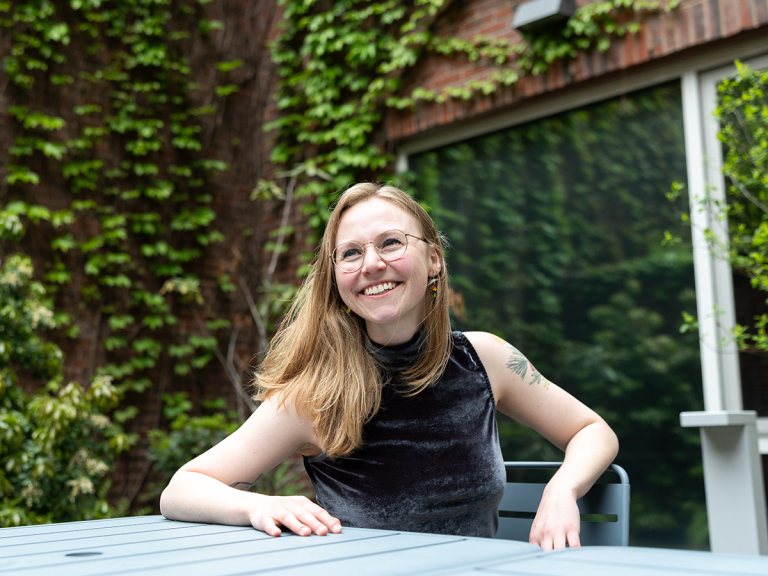 Gabriella Fleischman smiles against a backdrop of greenery.