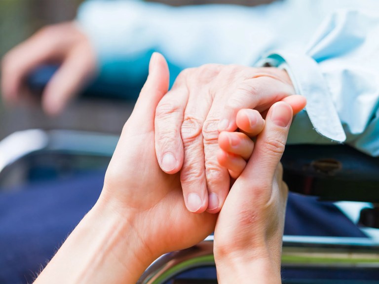 Someone holding an older person's hand
